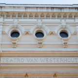 Una lastra marmorea con il nome del teatro e due medaglioni con maschere fa da cornice marcapiano. Oltre quest�ultima si innalza il livello superiore scandito da tre oculi archivoltati retti da doccioni modanati sovrastati da una merlatura che regge una mensola in pietra